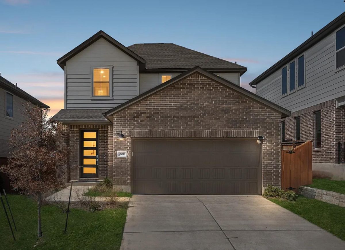 208 Table Top Bend, Liberty Hill, TX — two-story brick front at dusk