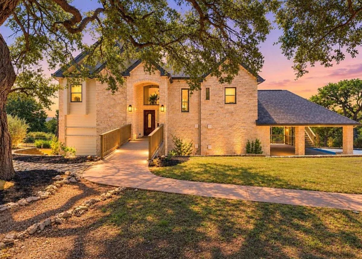 18113 Travis Drive, Leander, TX — stone front at dusk under the oaks
